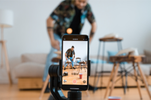 Blue Moon Marketing blog preview image of a smartphone filming a man creating short form video content, symbolizing the power of video, social commerce, and community-driven engagement in modern digital marketing.